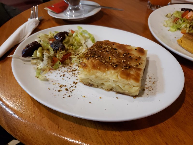 Salata ile servis edilmiş bir dilim peynirli börek